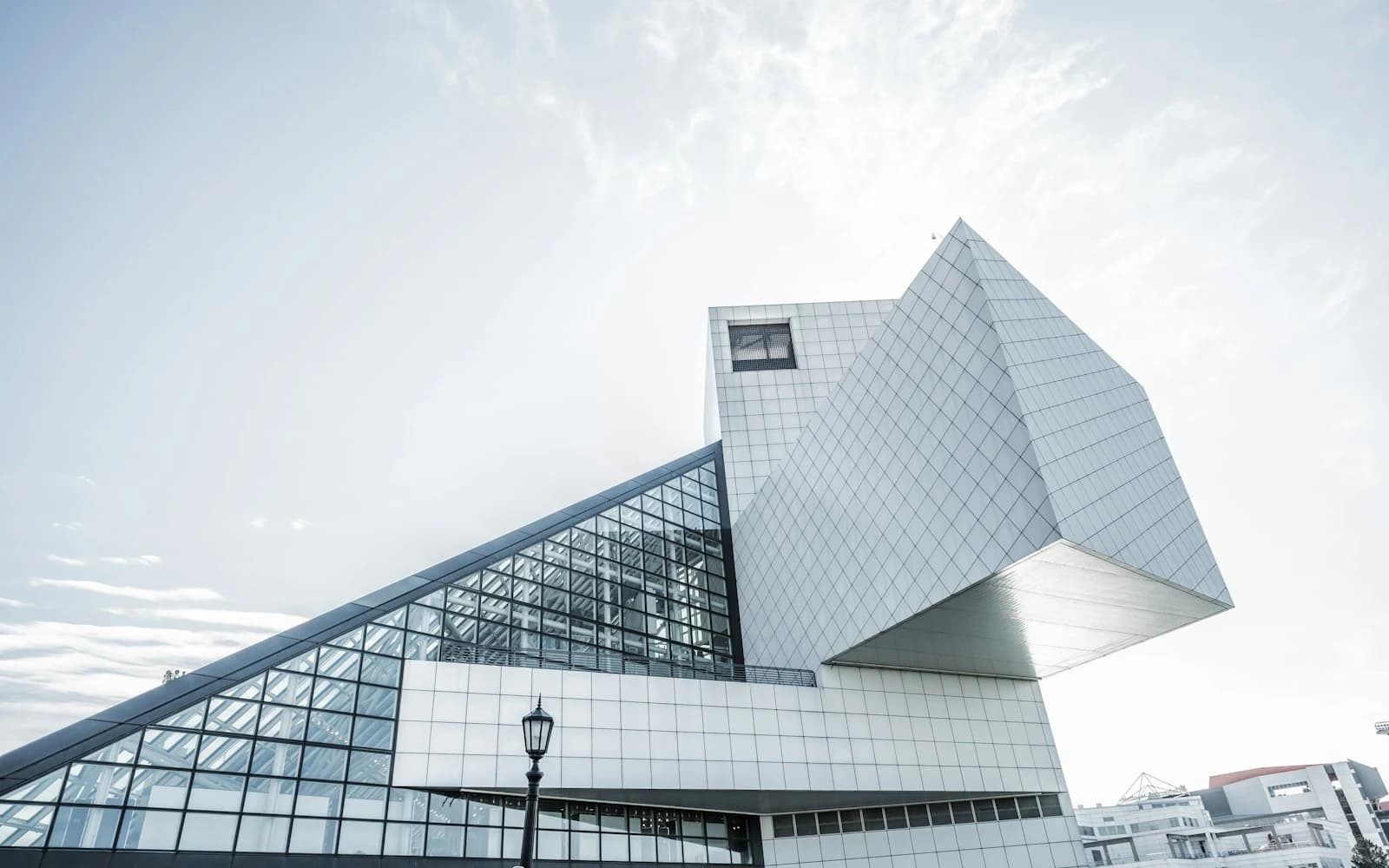 明亮天空下锐利悬挑的玻璃金属现代建筑
